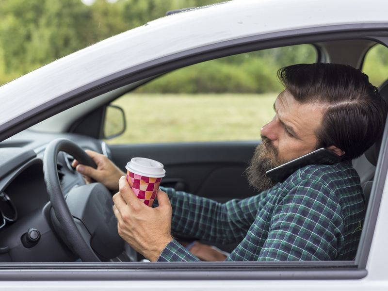 Muškarac u automobilu razgovara na mobitelu